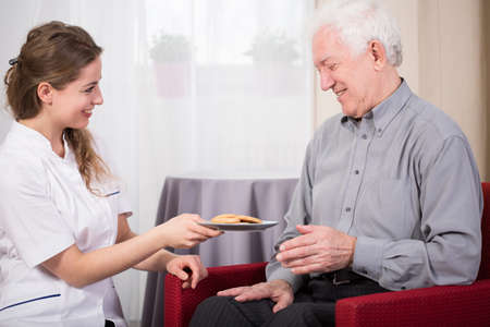 Care assistant and retired man at home