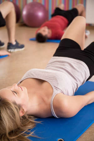 Young fit woman exercising bottom muscles on a mat