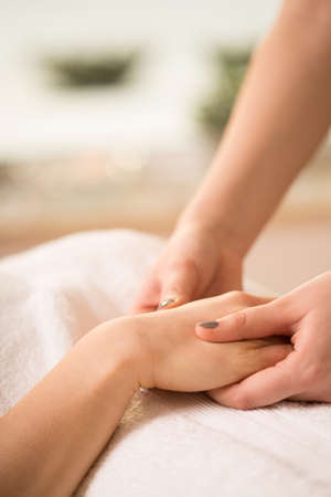 Close-up of female beautician doing hand massageの写真素材