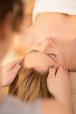 Close-up of woman relaxing during head massageの写真素材