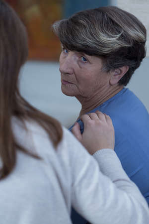 Granddaughter assisting her sad, depressed grandmother