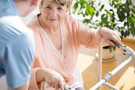 Horizontal view of nurse assisting disabled pensioner Horizontal view of nurse assisting disabled pensioner
