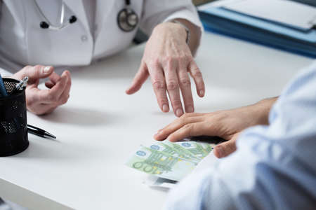 Close-up of doctor's hands refusing a bribe