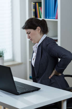 Office worker having backache caused by sedentary work