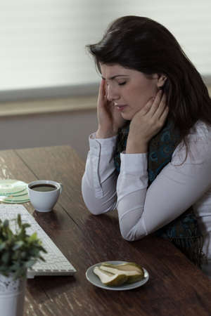 Portrait of ill businesswoman being at workの写真素材