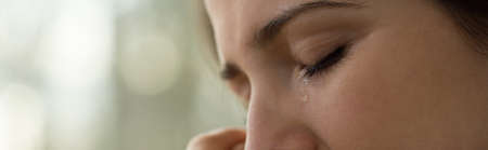 Close-up of young woman with problems crying