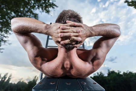 Athlete in park excercises his abdominal musclesの写真素材
