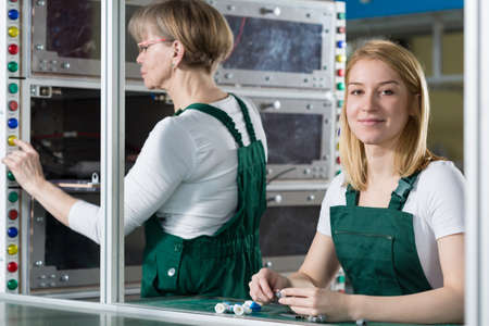 Young and mature woman working in manufacturing centreの写真素材