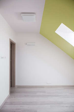 Interior of attic room with sloped ceilingの写真素材
