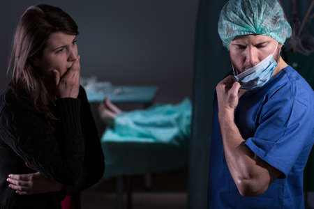Surgeon talking with woman about her husband's deathの写真素材