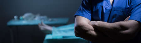 Surgeon guilty of patient's death standing with crossed armsの写真素材