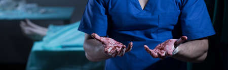 Surgeon with bloody hands guilty of patient's deathの写真素材