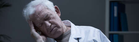 Overworked elder physician sleeping at work - panoramaの写真素材