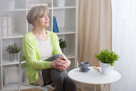 Thoughtful mature woman sitting at the table