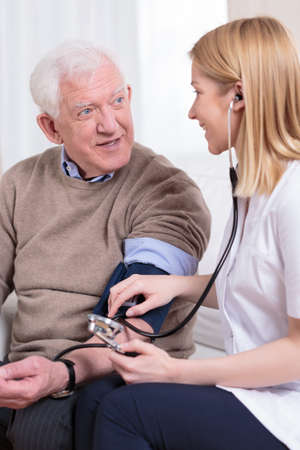 Nurse measuring blood pressure of senior manの写真素材