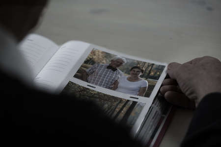 Close-up of older man browsing his photo album