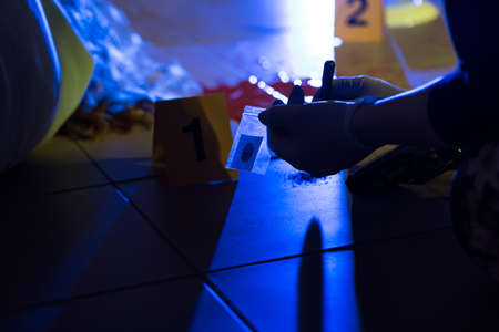 Close-up of forensic scientist preventing evidence of crimeの写真素材