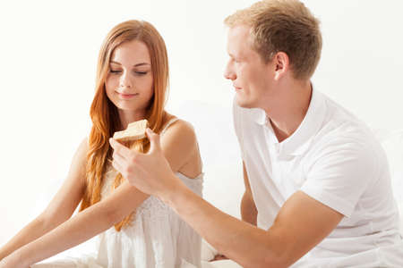 Lovers eating brakfast in a bed togetherの写真素材