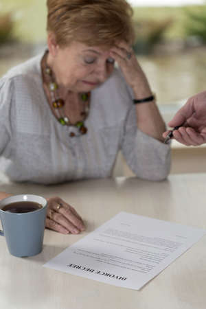 Aged broken down wife crying on divorce decreeの写真素材