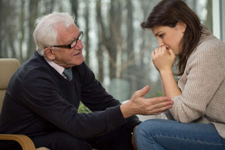 Elderly psychotherapist comfort his upset clientの写真素材