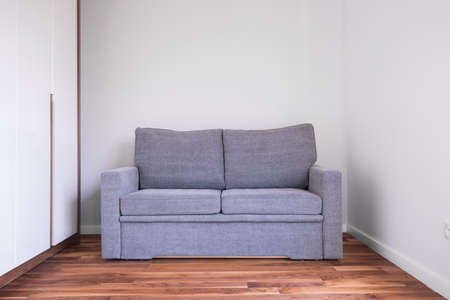 Small gray sofa in empty living roomの写真素材