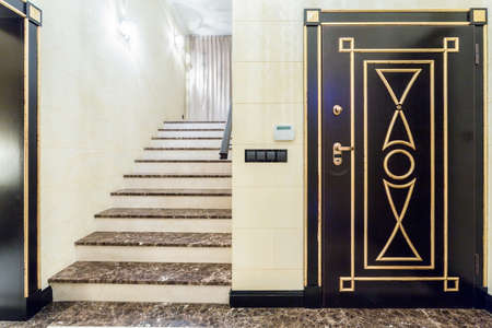 Wide marble stairs in fancy entrance hall with black doorの写真素材
