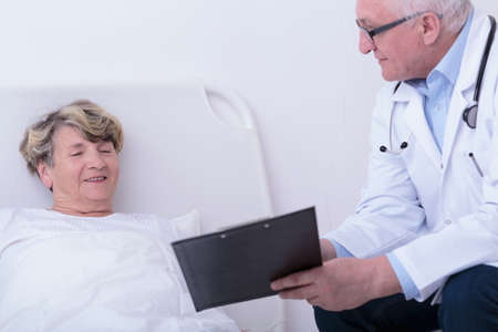 Aged woman and experienced doctor talking togetherの写真素材