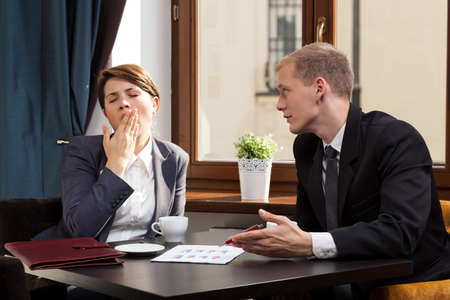 Businesswoman yawning during meeting in the cafeの写真素材