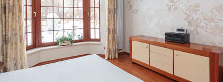 Panoramic view of bright bedroom with huge windowの写真素材