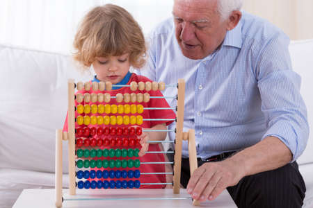 Grandfather and kid playing with abacus toyの写真素材