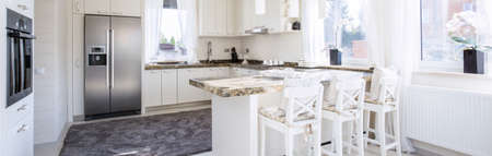 Spacious,white kitchen with counter-top dining placeの写真素材
