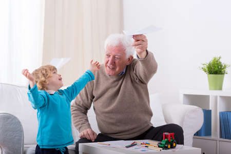 Happy little boy playing with paper airplaneの写真素材