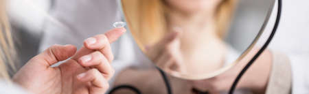 Close-up of contact lens on woman's fingerの写真素材