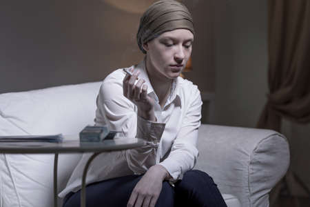 Image of lonely sad woman smoking cigaretteの写真素材