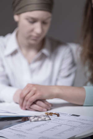 Depressed girl with carcinoma supported by friendの写真素材