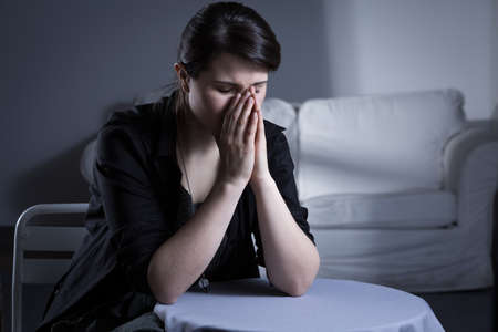 Despair divorced woman sitting at the table and cryingの写真素材