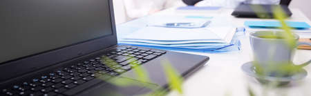 Laptop and cup of coffee on the tableの写真素材