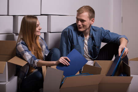 Young couple unpacking moving boxes in new houseの写真素材