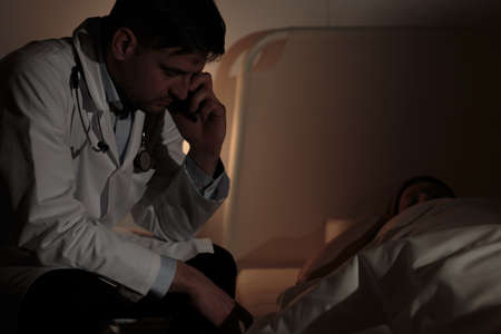 Doctor during night shift caring about cancer patientの写真素材