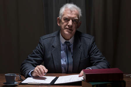 Elderly elegant man sitting alone in his study roomの写真素材