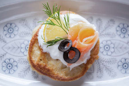 Tasty buckwheat blintz with cream, salmon, lemon and black oliveの写真素材