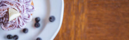 Delicious muffin with cream, blueberries and piece of white chocolateの写真素材