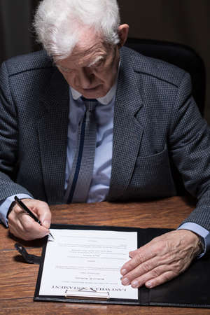 Senior elegant man signing his last will testamentの写真素材