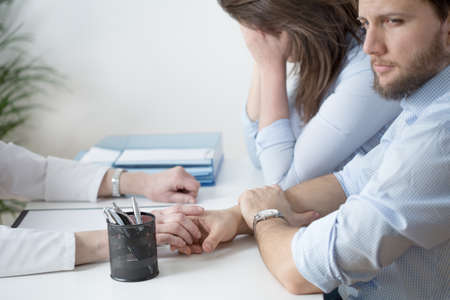 Young broken down couple at physician's cabinet