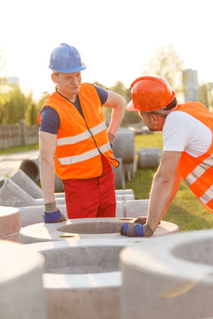 Tired construction workers having small talk at work