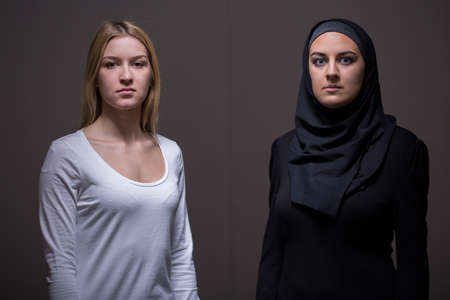 Caucasian and arab women on gray backgroundの写真素材