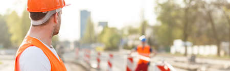 Close-up of builder in helmet looking at construction siteの写真素材