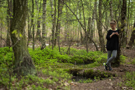 Young thoughtful woman walking in the forest