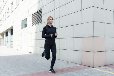Healthy young woman is runing in the city