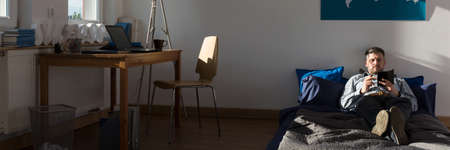Single man is bored in his modern apartment